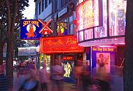 34_41203 Fr Hamburg Touristen ist die Reeperbahn der Ausgangspunkt fr den Besuch des Hamburger Rotlichtviertels. Die Werbetafeln leuchten im Abendhimmel und laden zum Besuch der Live Show im Moulin Rouge ein. Passanten schlendern ber die Sndige Meile, dem Kietz von Hamburg St. Pauli.