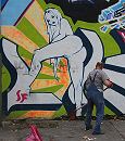 34_31213 Straenreinigung auf Hamburgs sndiger Meile: die Reeperbahn im Hamburger Stadtteil St. Pauli. Eine aufreizende, nackte Frau ist als Graffiti an die Hauswand gesprht, ein Mann subert darunter die Strasse mit einer Schaufel, im Vordergrund ein gefllter Mllsack.