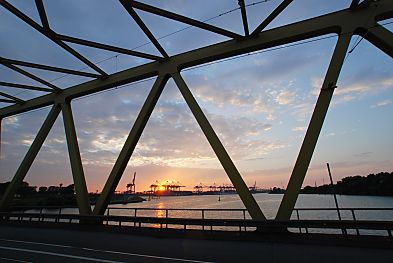 011_15878 - Blick durch die Metallkonstruktion der Brcke ber den Kattwyk zur untergehenden Sonne / Sonnenuntergang - die Containerbrcken des Containerhafens Altenwerder sind als Silhouette zu erkennen.