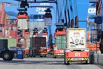79_6913 Unablssig transportieren die automatischen Transportfahrzeuge die Metallboxen von den Containerbrcken, die am Hafenkai stehen und die Schiffladungen lschen, zu den Lagerblcken. 