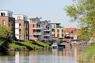 8064 Moderne Wohnungen am Ufer der Schwinge in Stade - Neubauten mit Balkon zum Wasser - Bootssteg mit Sportboot; im Hintergrund der Stader Hafen.