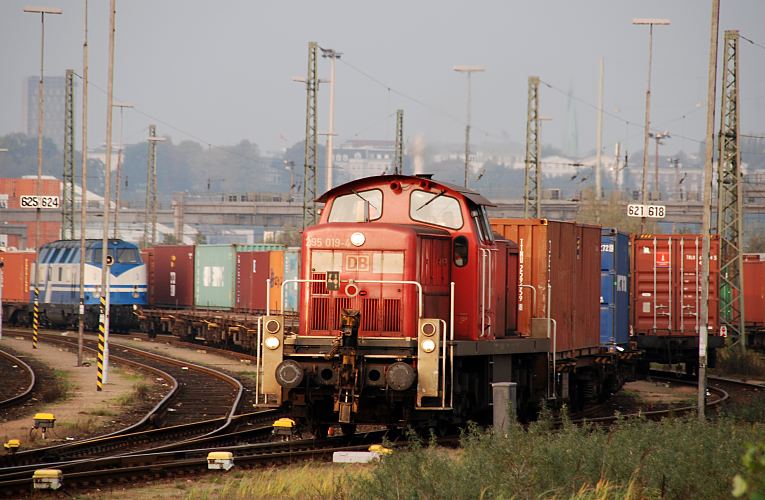 11_21387 Eine rote Rangierlokomotive zieht einen mit Container beladenen Gterzug. Die Hamburger Hafenbahn befrdert auf ihrem 330 km langen Schienennetz im Hamburger Hafen tglich ca. 220 Zge mit ber 4300 Waggons.  www.bildarchiv-hamburg.de