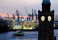 05_4525 Abenddmmerung ber dem Hafen der Hansestadt Hamburg - die eingedockten Passagierschiffe sind beleuchtet - es wird die ganze Nacht an ihnen gearbeitet. Eine beleuchtete Hafenfhre kommt von Finkenwerder und steuert die Landungsbrcken an. Im Vordergrund die beleuchteten Uhren des Uhren- und Pegelturm an den St. Pauli Landungsbrcken.