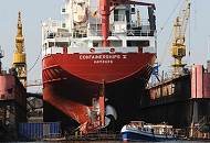 23_26-5959 Das Frachtschiff CONTAINERSHIPS V mit Heimathafen Hamburg liegt im Dock der Norderwerft am Reiherstieg. Eine Barkasse der Hamburger Hafenrundfahrt fhrt an dem Heck des Containerfeeders vorbei. 