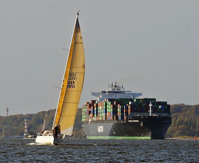 11_21417 Fotos von Schiffen in Hamburg : Containerschiff Hatsu Courage :Der Containerfrachter HATSU COURAGE auf der Elbe - im Hntergrund die Leuchttrme / Leuchtfeuer von Hamburg Wittenbergen; eine Segelyacht liegt im Wind. Das Containerschiff Hatsu Courage ist 334,00 m lang und 42,80m breit, es fhrt 25 Knoten / kn. Der Frachter lief 2005 vom Stapel und hat bei einem Tiefgang von 14,50 m eine gross tonnage von 90449 und eine nett tonnage von 55452 und kann 8073 Standartcontainern / TEU Ladung an Bord nehmen.  www.bildarchiv-hamburg.de