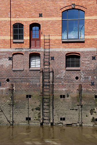 011_17375 - Fassade eines Lagergebudes in der Speicherstadt Hamburgs - eine Eisentreppe fhrt vom Fleet zu einer Tr; es ist Ebbe im Hafenfleet, dies zeigt die Markierung an der Wand des Gebudes. 