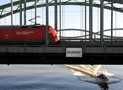 011_17399 - ein Motorboot fhrt in voller Gleitfahrt unter die Elbbrcke - oben ein roter Triebwagen.