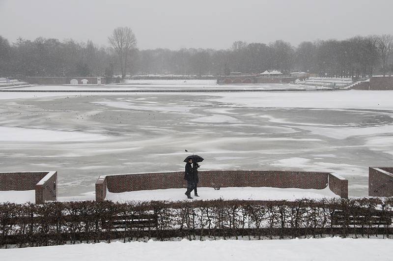 Hamburger Winter - Grauer Wintertag am Stadtparks, Hamburger Stadtpark. 268_5042 An einem grauen Wintertag geht ein Paar am Stadtparksee spazieren - sie schtzen sich mti einem Schirm gegen den Schneefall. Auf dem fast zugefrorenen See sitzen Mwen auf dem dnnen Eis. Im Hintergrund das Freibad Stadtparksee