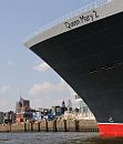 01_4330 Bug der Queen Mary 2 am Kreuzfahrtterminal im Hamburger Hafen. Im Hintergrund die modernen Gebude der Hafencity und die Kuppel vom Hamburger Wahrzeichen dem Michel. 