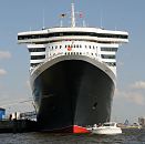 03_4359 Das Kreuzfahrtschiff Queen Mary 2 liegt festgetut am Kai des Cruise Centers im Hamburger Hafen. Passagiere einer weissen Motoryacht sitzen an Deck und betrachten das grosse Schiff von der Nhe. Die R.M.S. (Royal Mail Ship)  Queen Mary 2 (QM2) ist mit 148.528 BRZ eines der grten Passagierschiff der Welt. Das britische Kreuzfahrtschiff  hat eine Lnge von 345 m und eine Breite von 45 m. Der Luxusliner bietet in 1310 Kabinen bis zu 2.620 Passagieren Platz und hat eine Besatzung von 1.253 Personen. www.fotograf-hamburg.de