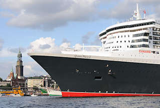 8570 Queen Mary 2 luft aus dem Hamburger Hafen aus - das Passagierschiff fhrt Hhe St. Pauli Landungsbrcken - an Land die Gustav Adolf Kirche und der Michel.